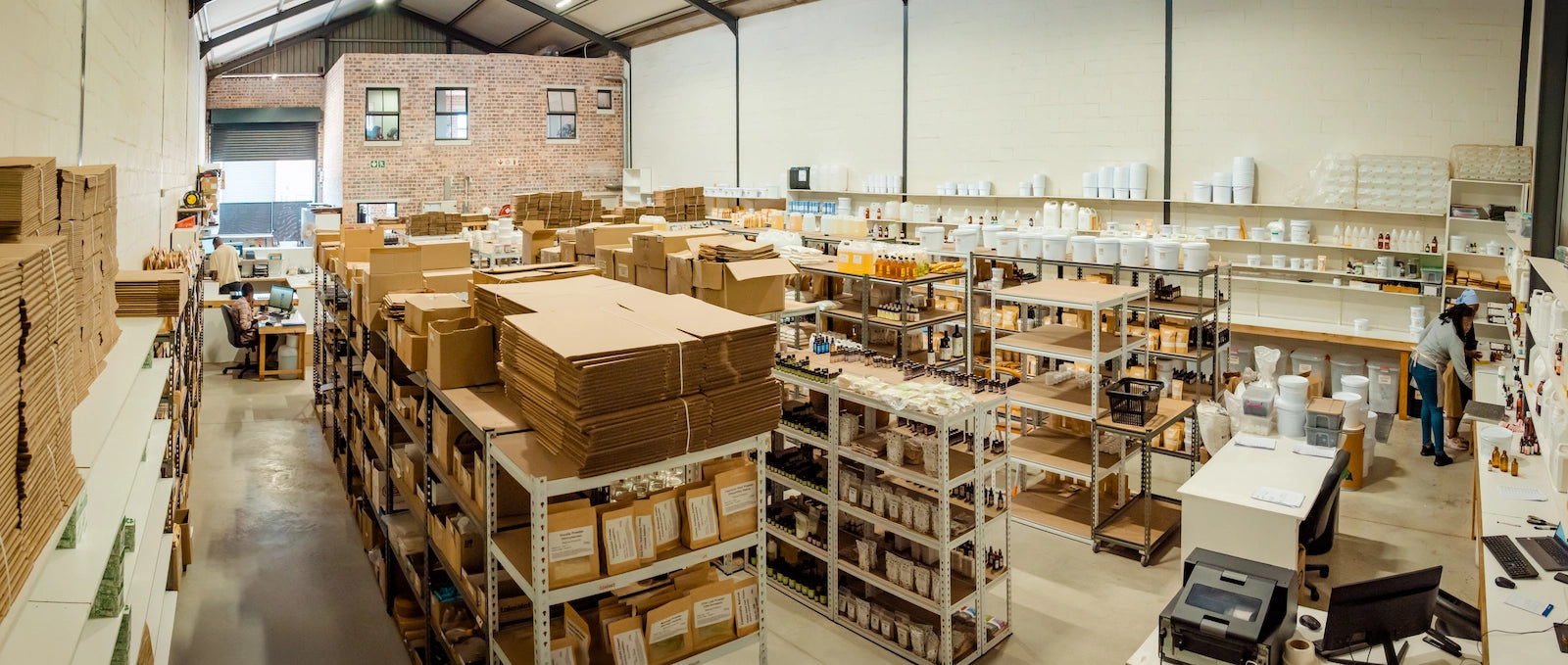 Inside the Essentially Natural working warehouse with product shelves and workstations